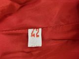 the back of a red jacket with a white label on it