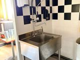 un évier dans un coin de la cuisine, devant un mur à carreaux noirs et blancs