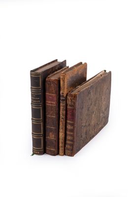 plusieurs vieux livres sont empilés sur une surface blanche