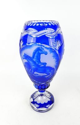 un vase bleu orné d'un cheval sur fond blanc