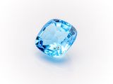 a close up of a blue topazte gems on a white surface