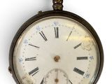 un gros plan d'une montre de poche ornée de chiffres romains