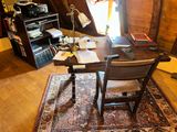 a desk with a chair and a lamp in a room