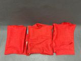 un lot de trois serviettes rouges sur fond gris
