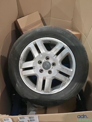 une boîte contenant un pneu et une boîte sur laquelle sont posées plusieurs boîtes