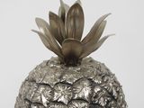 a silver vase with a pineapple on top of it
