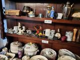 many different types of dishes and bowls on the shelf