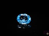 a close up of a blue topaz diamond on a black surface