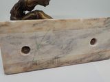 statue of a bird perched on a wooden block with holes in it