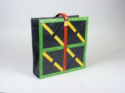 une valise noire ornée d'un motif vert et jaune