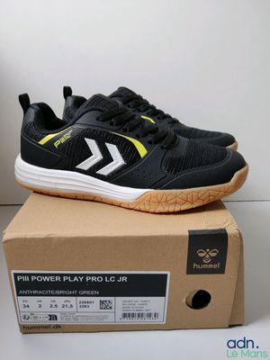 un gros plan sur une paire de chaussures noires et jaunes posées sur une boîte