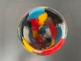 a glass with a colorful liquid inside of it on a table