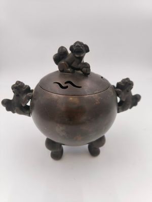 an antique bronze incense box with three monkeys on it