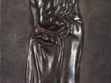 statue d'un homme en robe tenant un livre, posée sur un socle