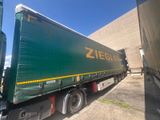 a green semi truck that is parked in front of a building
