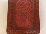 un vieux livre à la couverture rouge posé sur une table blanche