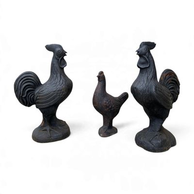 trois figurines de coqs sur fond blanc