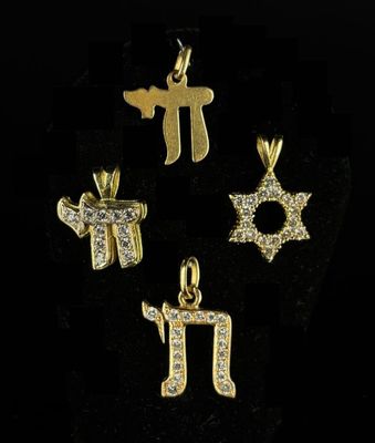 a set of four gold plated charms with hebrew symbols