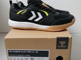 La boîte contient une paire de baskets noires et jaunes.