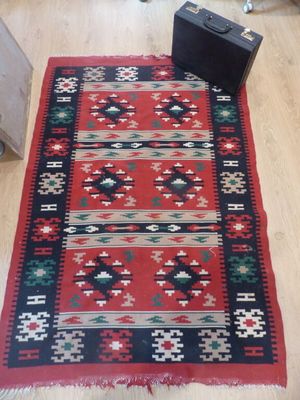 un tapis rouge et noir posé sur un parquet