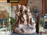a statue of a group of children sitting on a rock