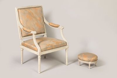 a chair and foot stool sitting next to each other
