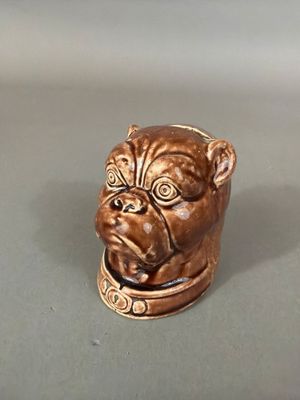 une petite figurine représentant un chien avec un collier autour du cou