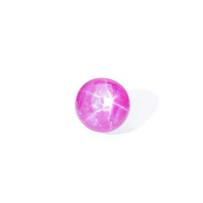 a close up of a pink ball on a white surface