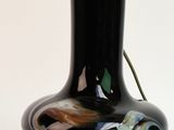 un vase noir contenant une fleur, posé sur une table