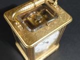 a gold clock sitting on top of a black table