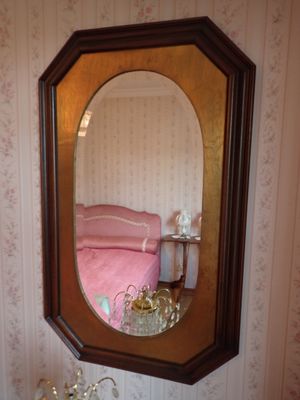 un miroir sur le mur au-dessus d'un lavabo dans une salle de bains