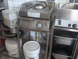 a kitchen with a stove, sink, and buckets on the floor