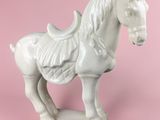 a white horse statue on a pink background