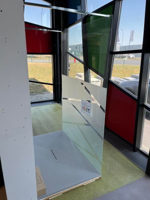 une photo d'une cabine de douche en verre dans un immeuble