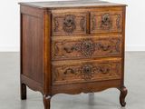 une vieille commode en bois dont les tiroirs sont ornés de sculptures