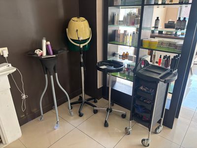 une photo d'un salon de coiffure avec un sèche-cheveux et un fauteuil