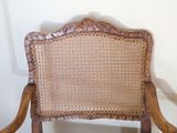 a wooden chair that has a woven seat on it
