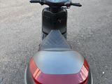 un scooter rouge et noir garé sur le bord de la route
