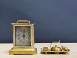 a small gold clock and a miniature boat on a table