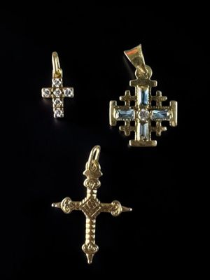 a close up of a cross and a cross pendant on a black background