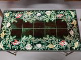 a small table with a glass top and flowers on it