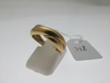 une image représentant une bague en or posée sur une surface blanche