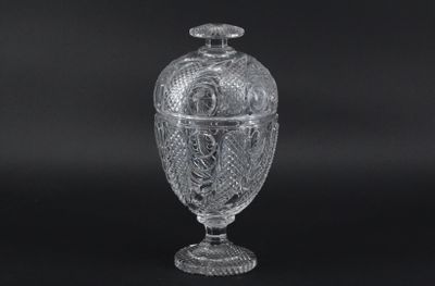 une urne ancienne en verre taillé sur fond noir, avec un fond noir