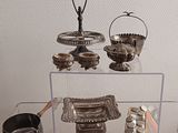 a glass display case with silver objects on it