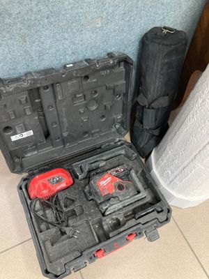 deux outils dans une mallette posée par terre à côté d'une poubelle