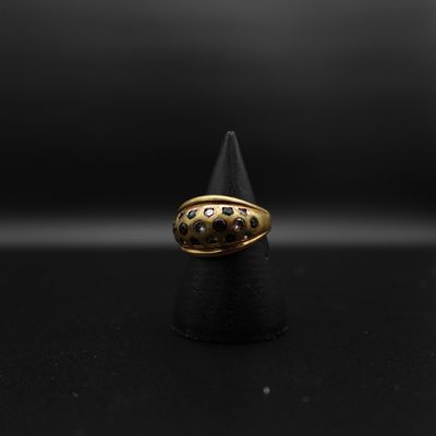 gros plan d'une bague en or sur une surface noire
