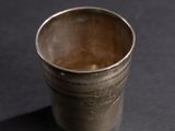 an old silver cup sitting on top of a black table
