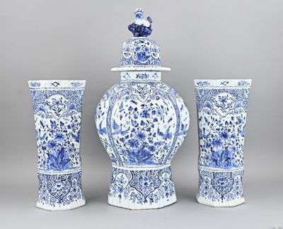 three blue and white vases and a vase with a bird on top