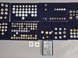many different types of coins in a display case