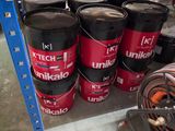 many buckets of different types of paint on a shelf
